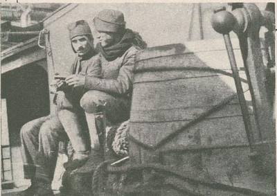 Dois soldados do C.E.P. tomam a sua refeição a bordo de um navio para França.